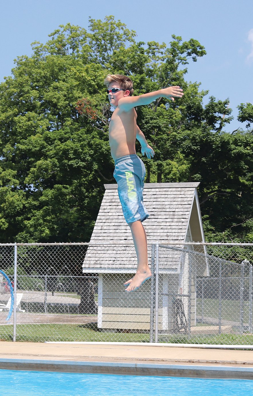 Shawn Ewoldt, 12, prepares for the "toothpick" reverse dive after bouncing off the Milligan Park Pool diving board on Thursday.